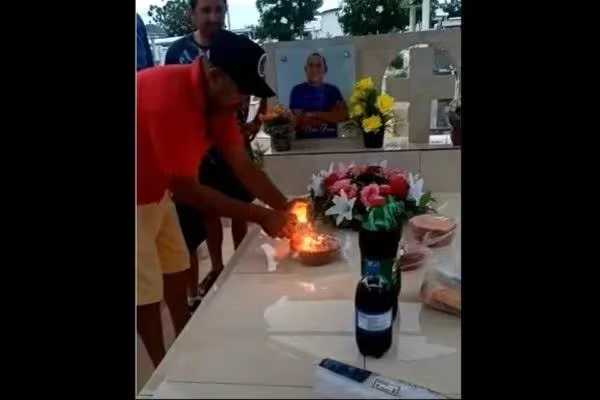 Homem comemora aniversário em cemitério e coloca bolo sobre o próprio túmulo